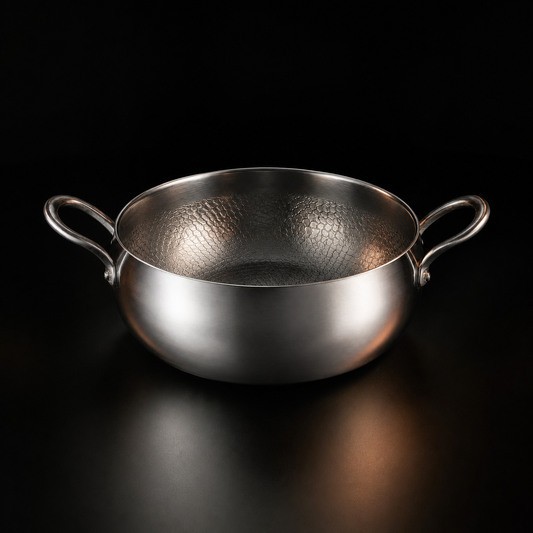 Hand-hammered deep titanium pot simmering a stew, PFAS-free cookware