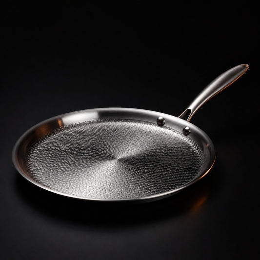 Hand-hammered flat titanium crêpe pan cooking a crêpe, PFAS-free cookware